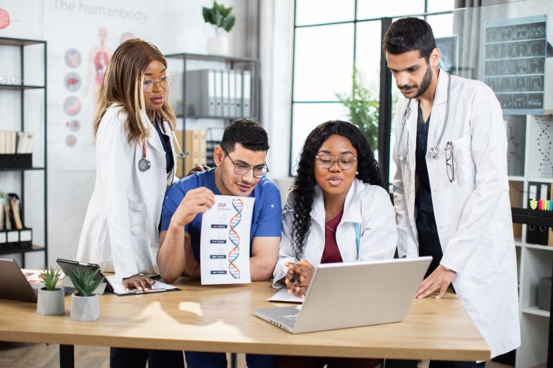 medical group of doctors biochemists, having online video call on laptop DNA code, science concept. Skilled diverse medical group of doctors biochemists, having online video call on laptop, and discussing information about gens and chemical formulas